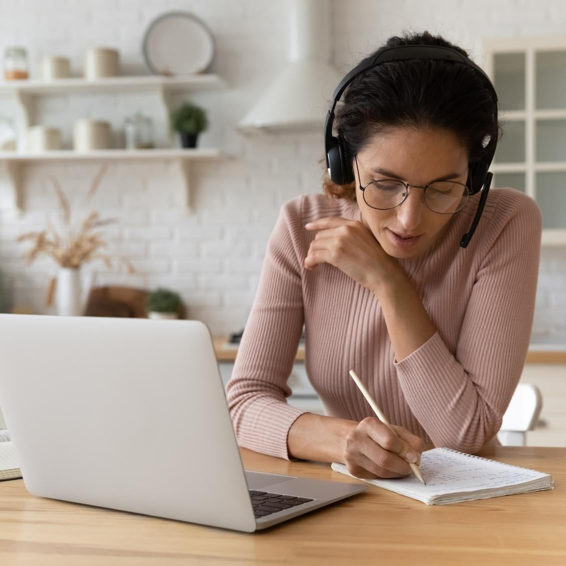 An educator smiling while taking an online course at her laptop